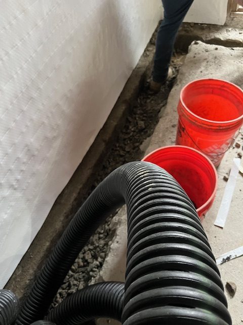 basement while team is working on interior basement waterproofing