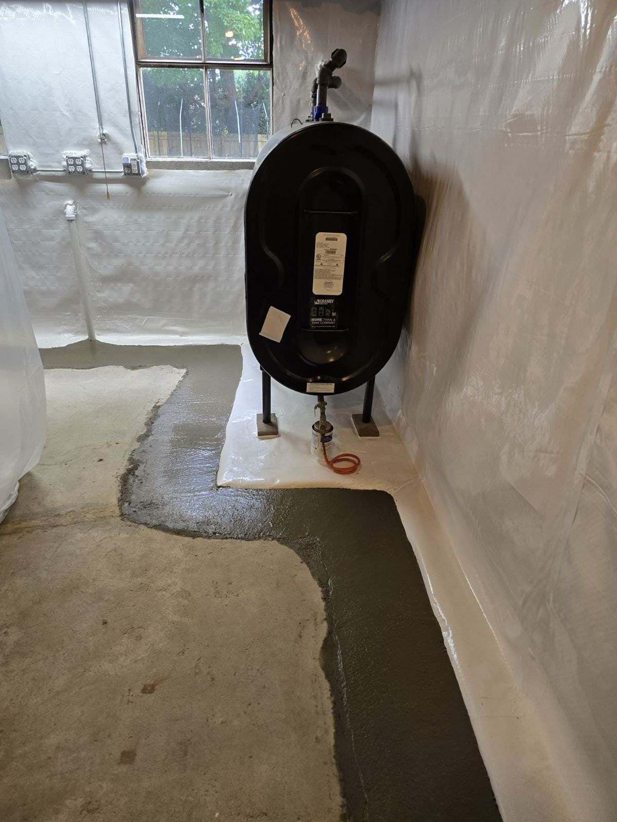 basement floor with new concrete for the waterproofing services in process